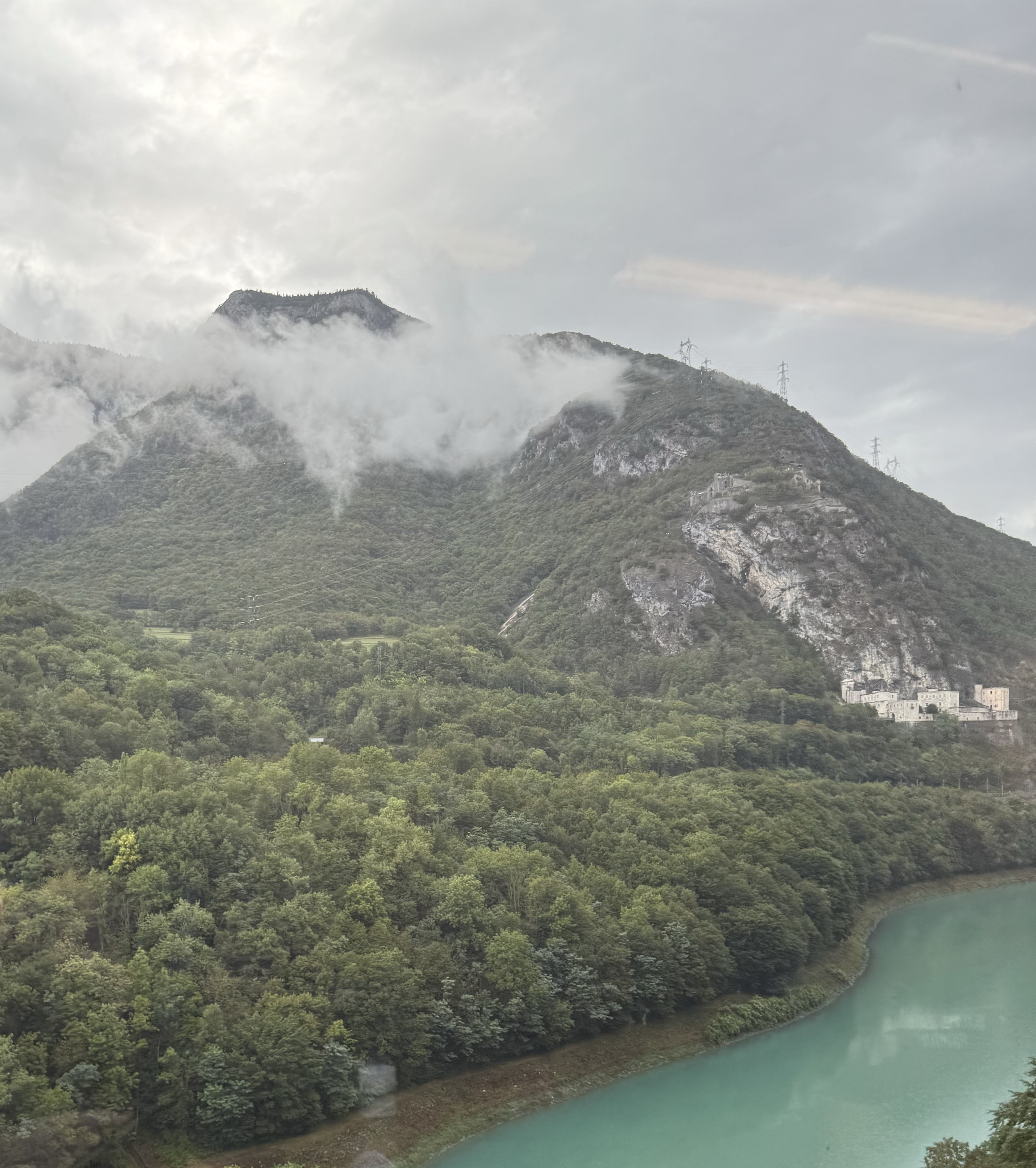 A mountain partially obscured by a cloud, and a river in the foreground.