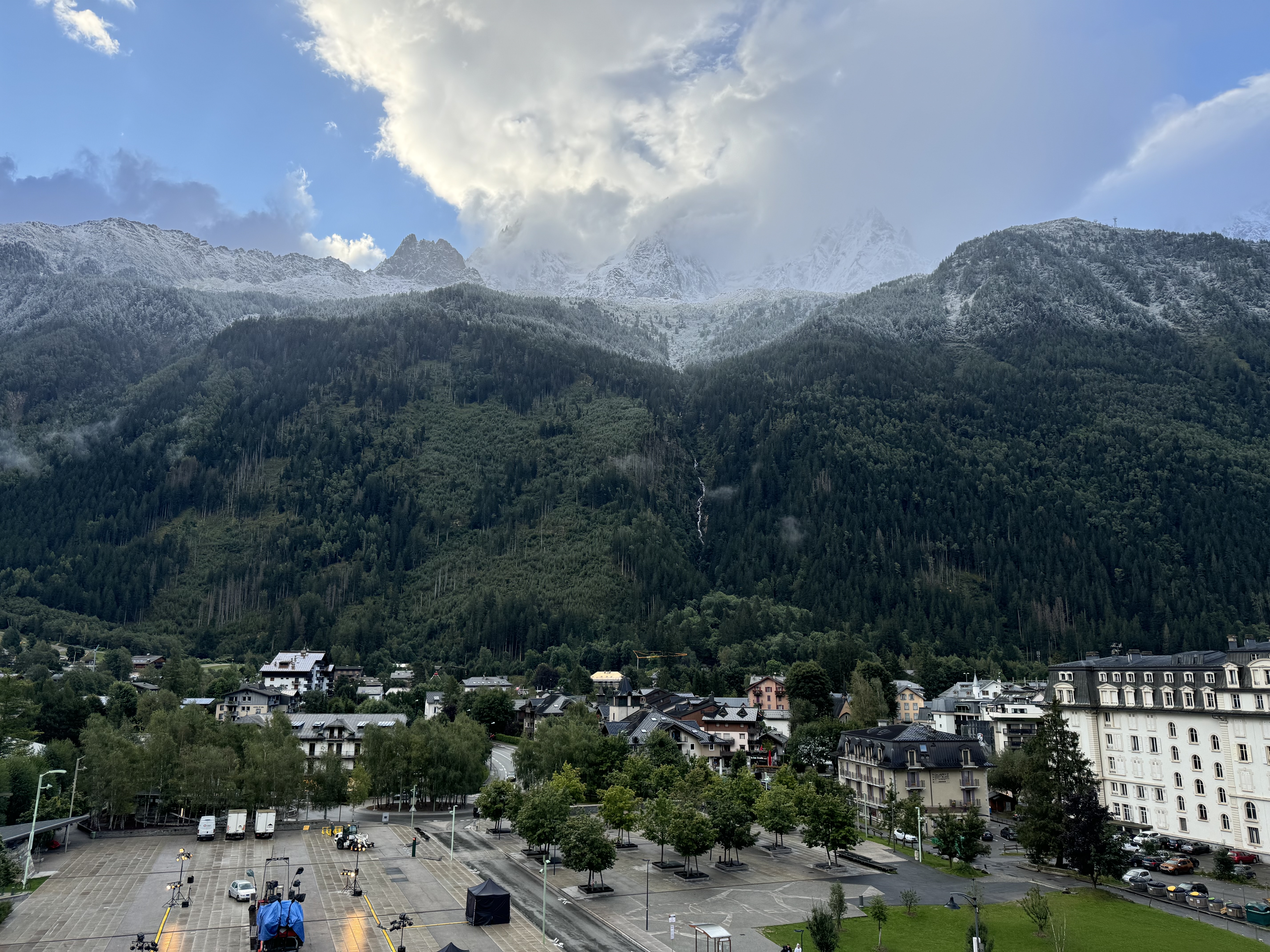 Mountains with a distinct frost line and clouds, with the city of Chamonix, FR in the foreground.